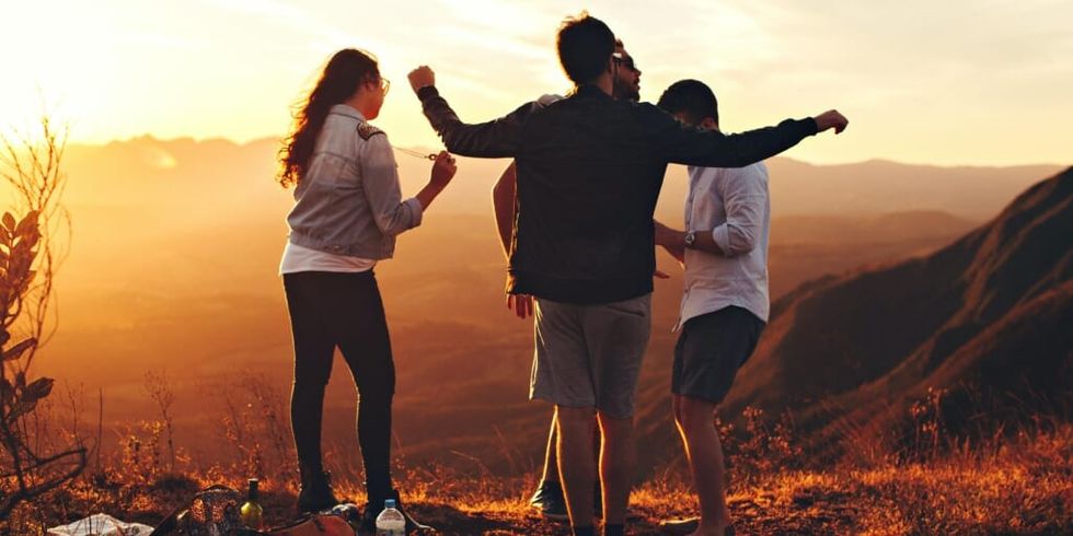 Group of friends overlooking hills at sunset by Helena Lopes on Unsplash