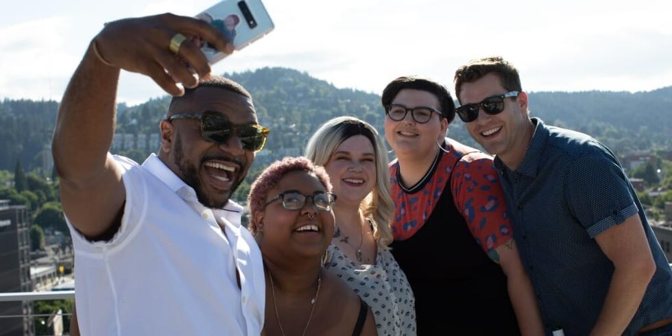 Group of friends taking selfie on rooftop overlooking city by Allgo on Unsplash