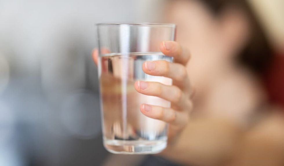hand holding glass of water