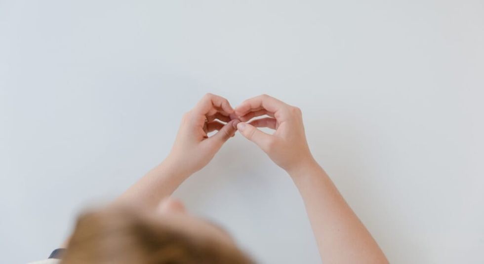 Hands forming a heart in sign language.