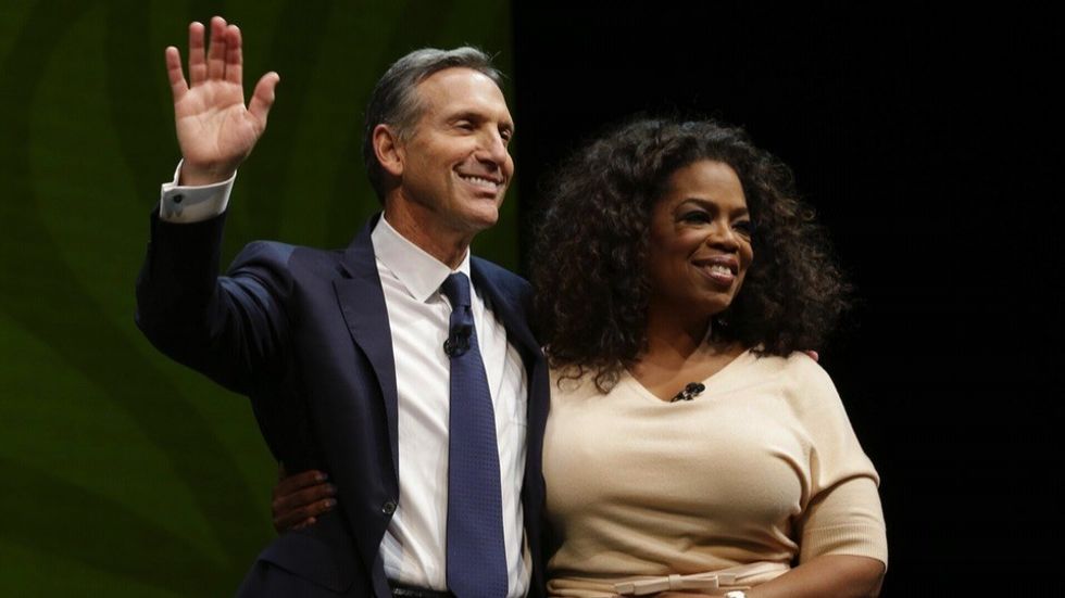 Howard schultz hugging oprah winfrey and waving to crowd