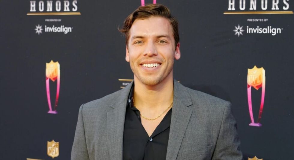 Joseph Baena in grey suit and black shirt on red carpet