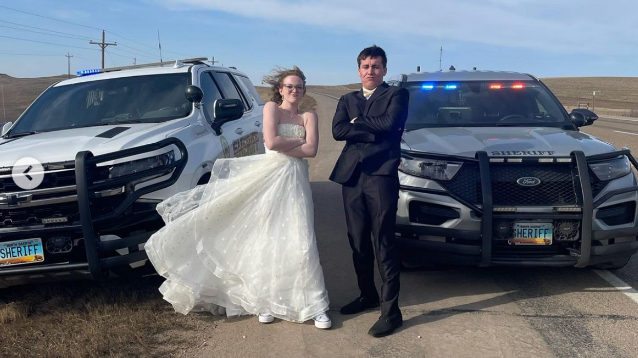 Killdeer High School juniors Danica Mindt and Ian Gloria taking prom photos in front of Dunn County Sheriff's Dept. vehicles.