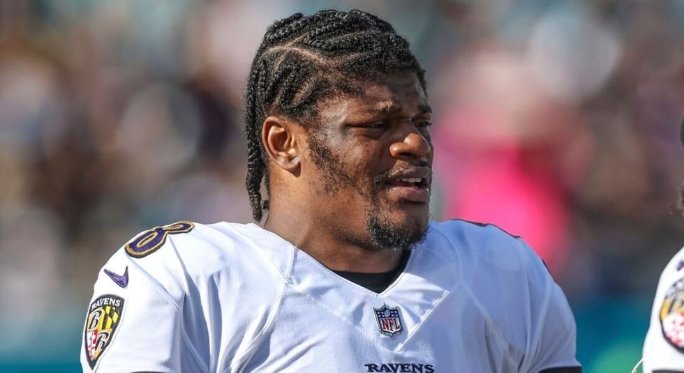 Lamar Jackson on the field in white jersey.