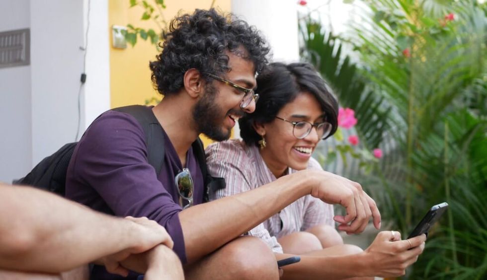 laughing couple looks at entertainment on phone