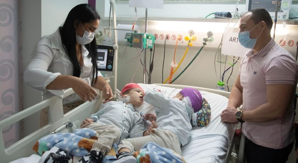 Lima parents looking at their sons after surgery.