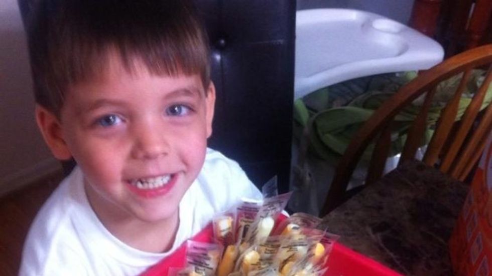 little boy holding food in his hands