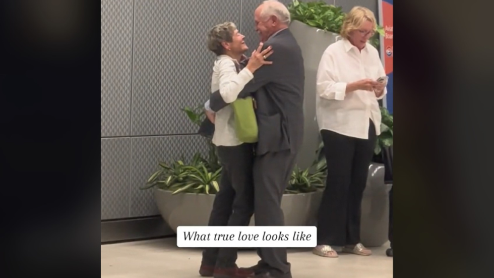 man and woman embracing in airport