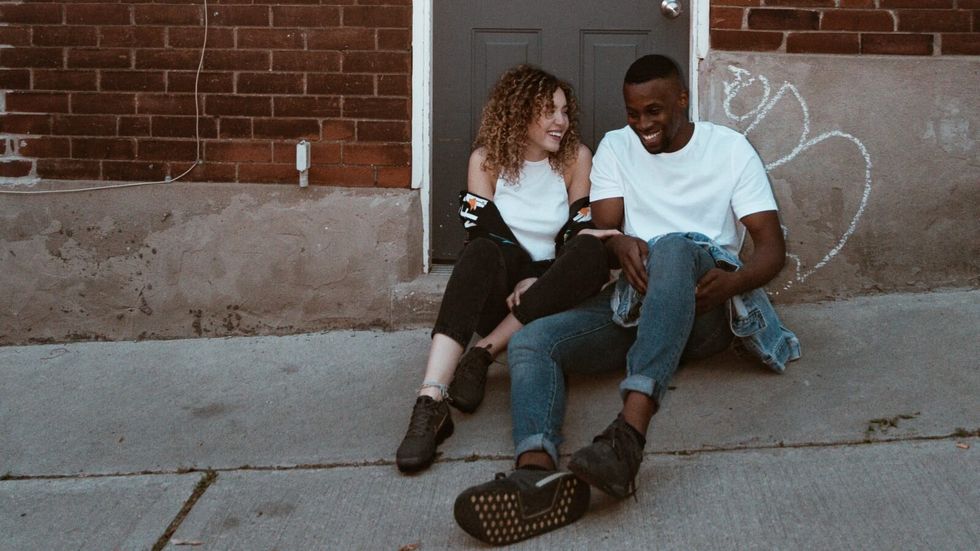 man and woman sitting outside a door