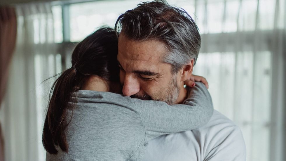 man carrying and hugging his daughter