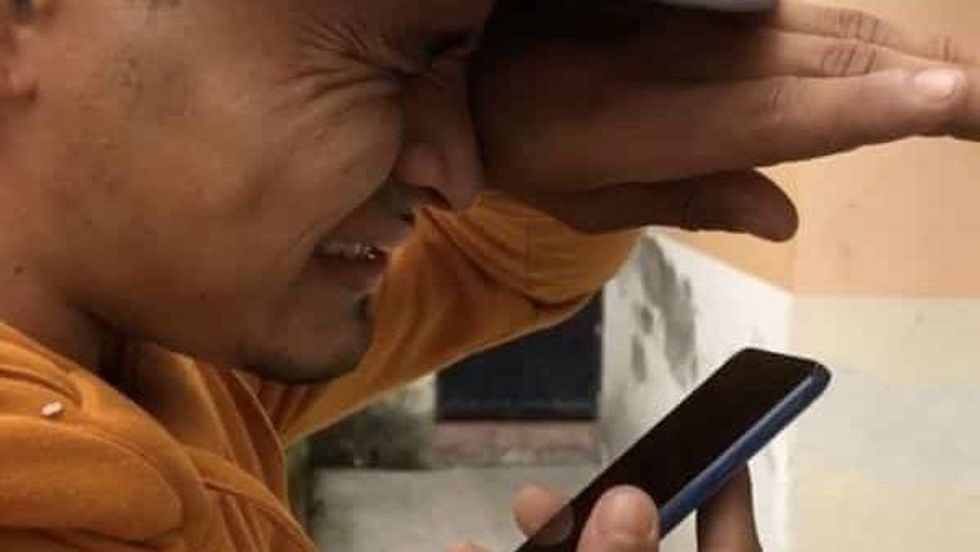 man crying while speaking on the phone