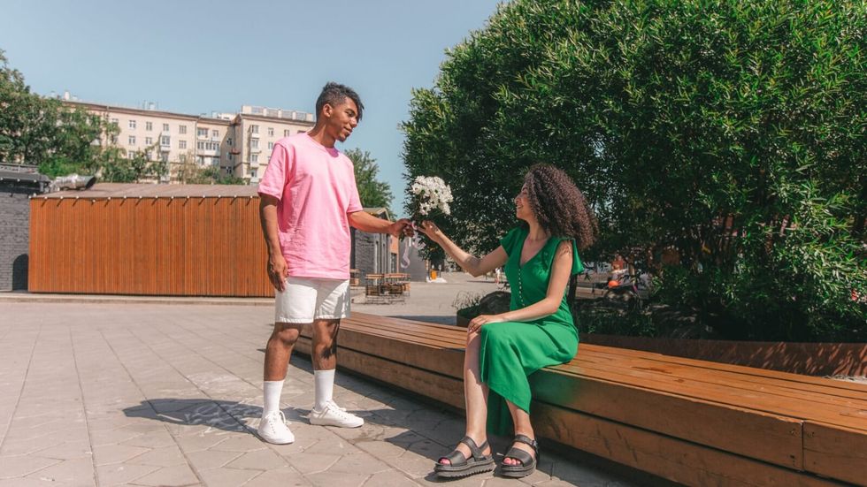 man giving flowers to a woman