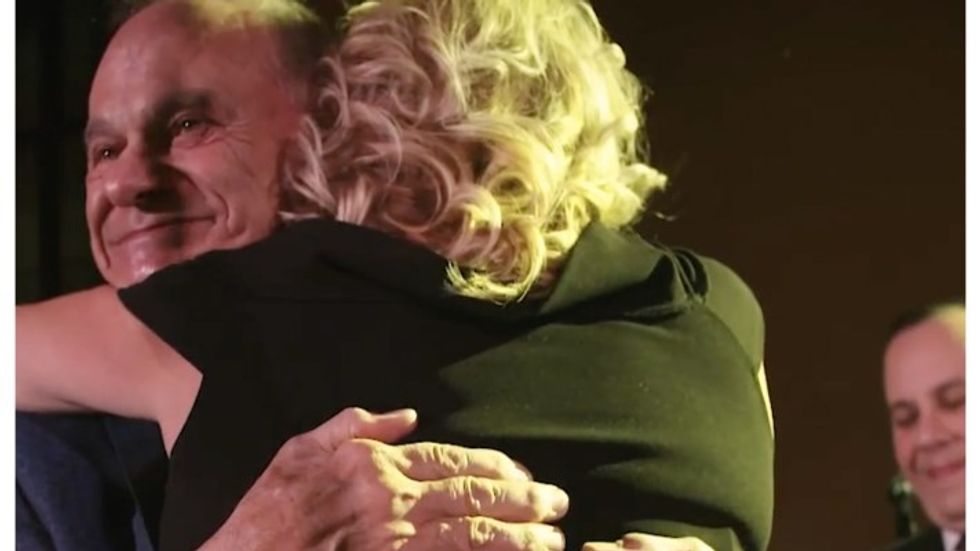 man hugging a blond haired woman