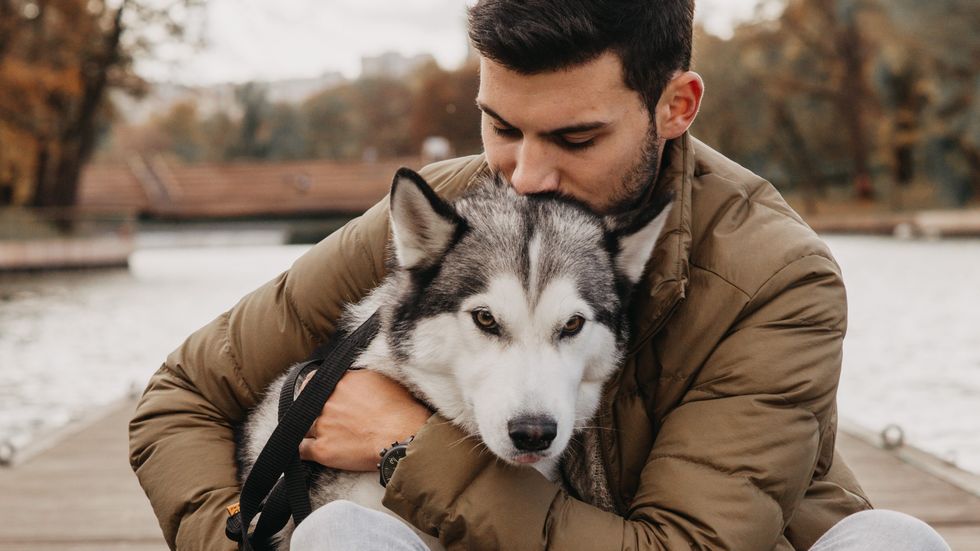 man hugging his dog