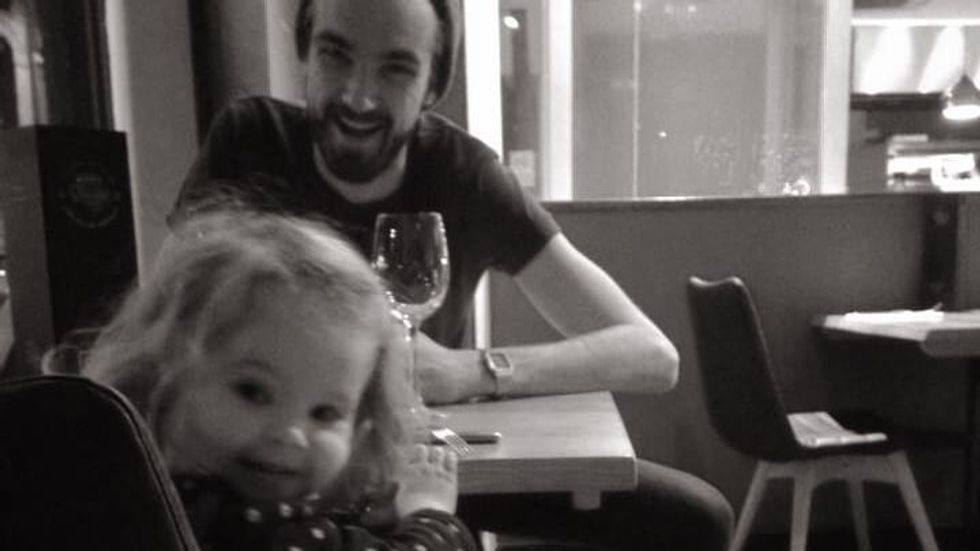 man in a beanie sitting at a table with a little girl
