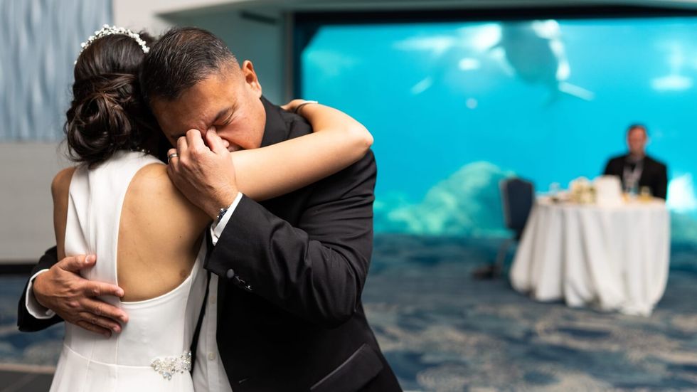 man in a black suit dancing with girl in a white dress
