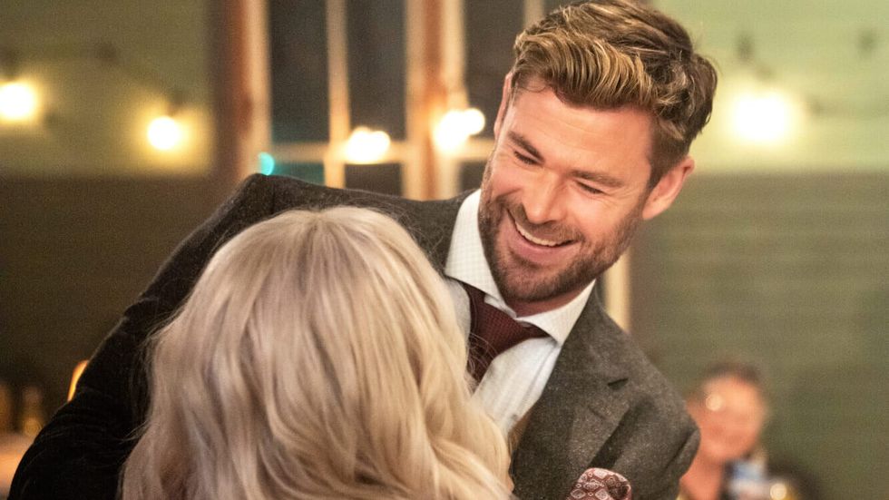 man in a suit smiling at another person