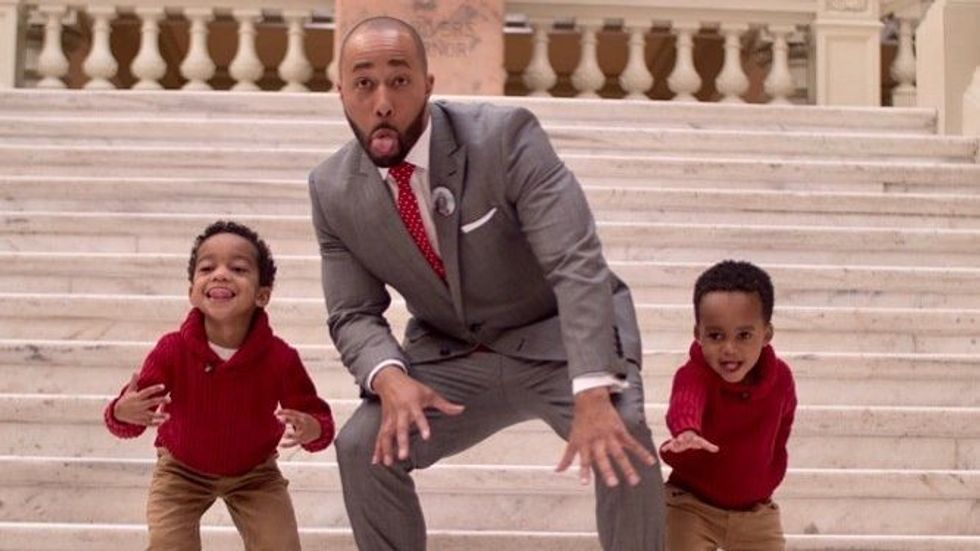 man in a suit with two young sons
