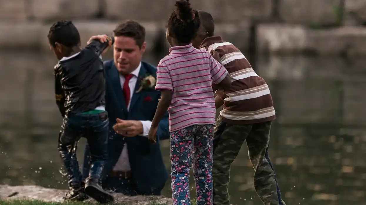 Man in river drags kid out.