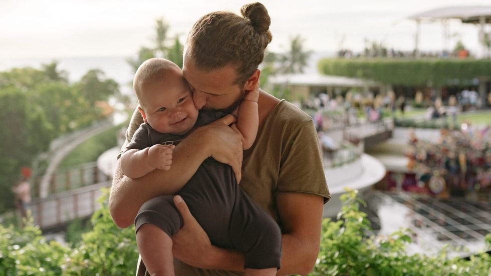 man kissing a baby's cheek