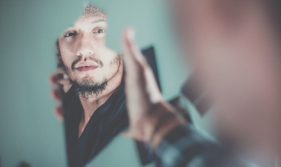 man looks at his reflection