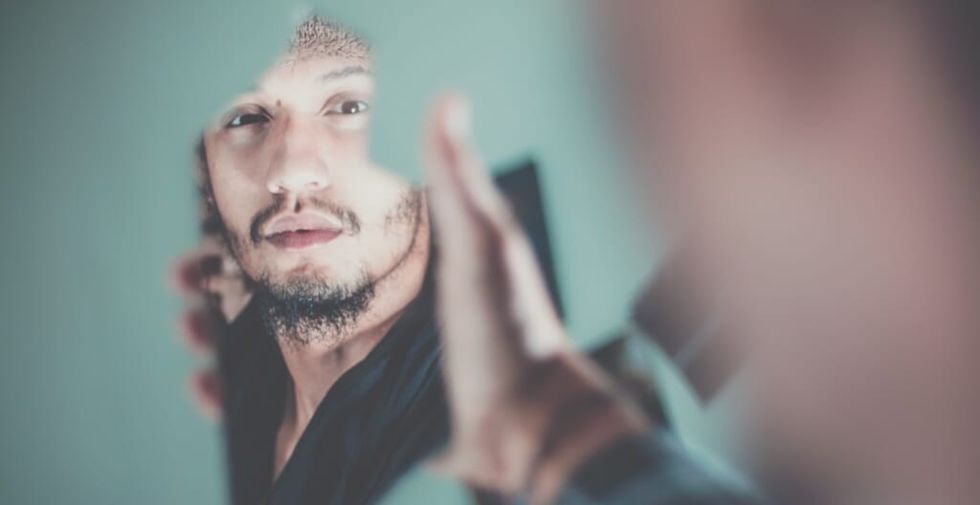 man looks in mirror
