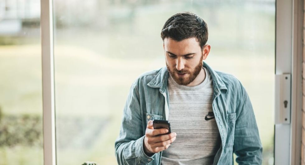 man on phone checking texts