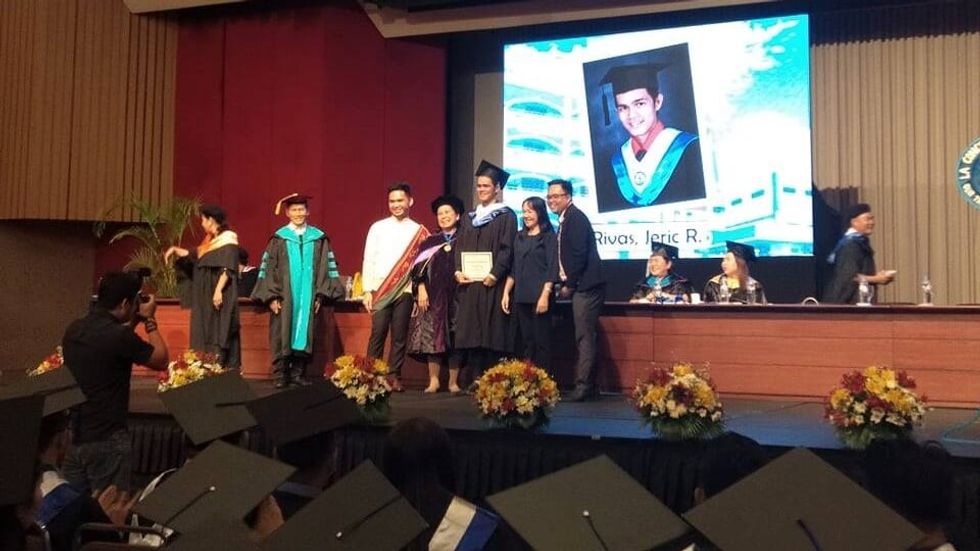 man on stage at his graduation ceremony