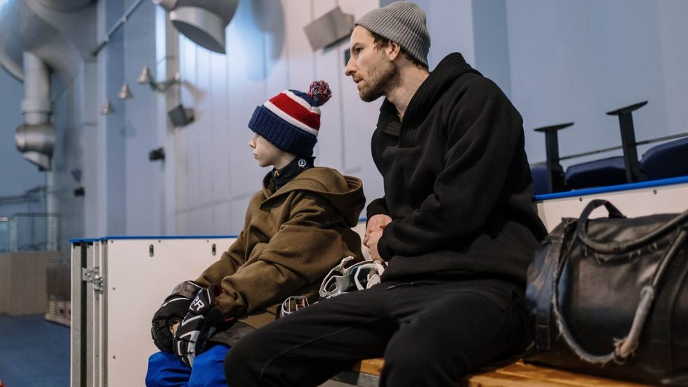 man sitting with a young child on a bench