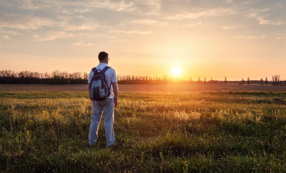 man-standing-field-contemplating-priorities