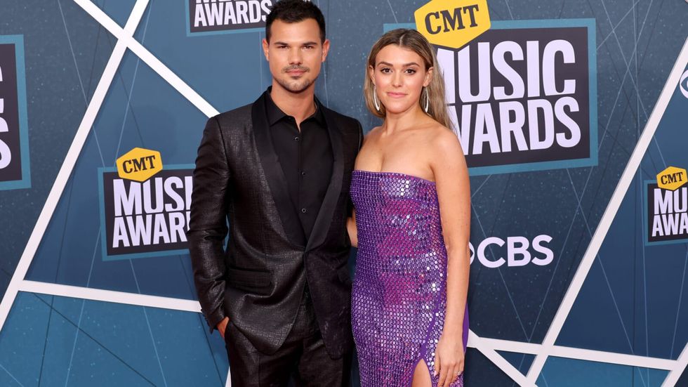 man wearing a black suit and a woman wearing a sparkly purple full length dress