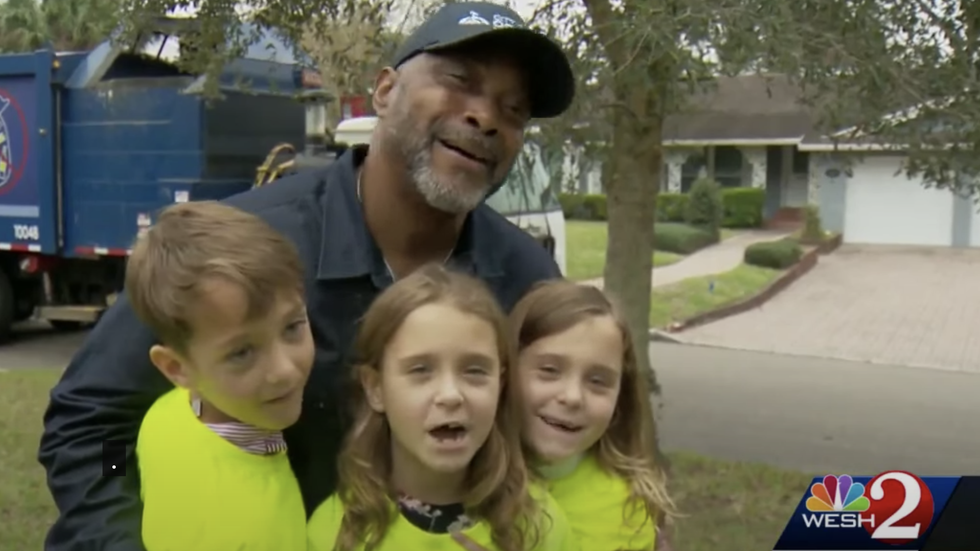 man wearing a cap hugging three kids