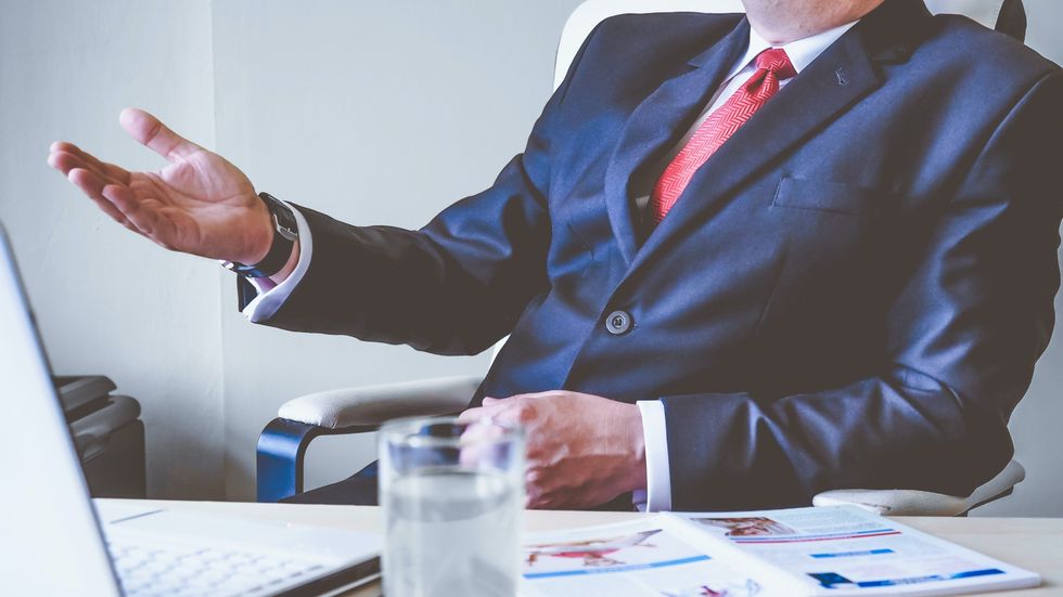 man wearing a suit sitting at a desk