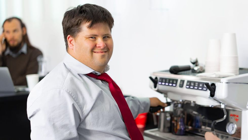 man with down syndrome smiling wearing a red tie