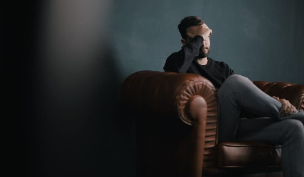 man with face on hand in therapy