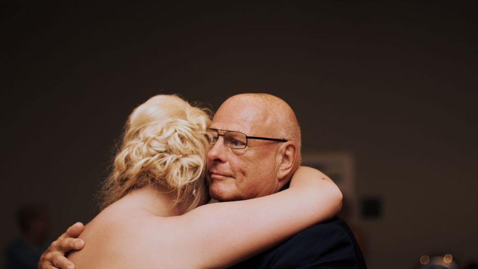 man with glasses hugging and dancing with a woman with blond hair