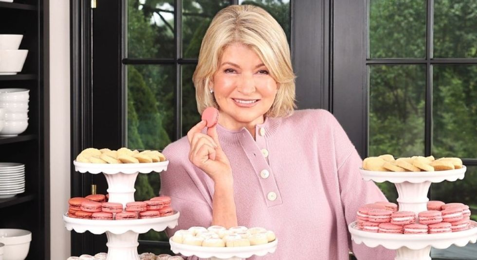 Martha Stewart holding up a dessert and smiling.