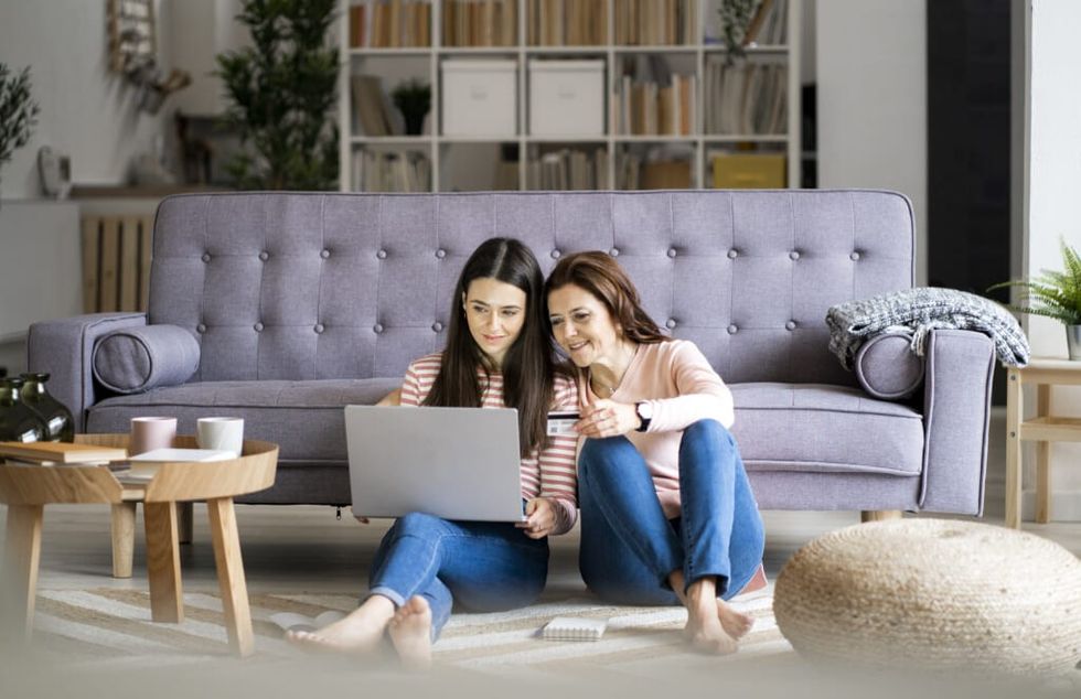 mom and daughter browse the internet on a laptop