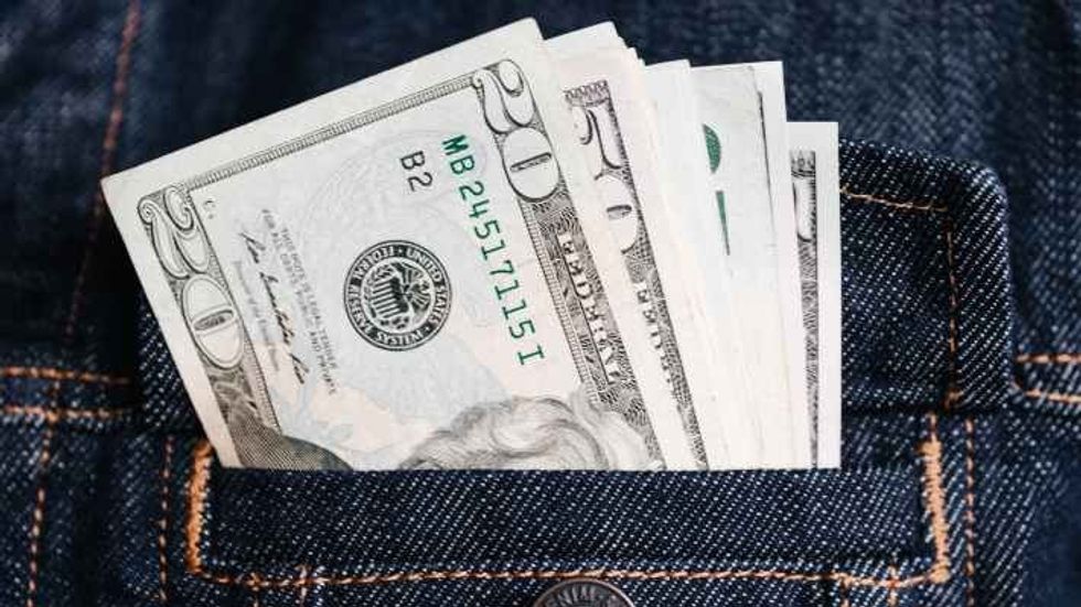 money in a denim jacket pocket