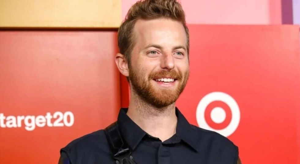 Ned Fulmer in black suit smiling at the camera.