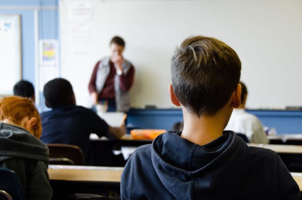 Over the shoulder view of student looking at a teacher at a white board