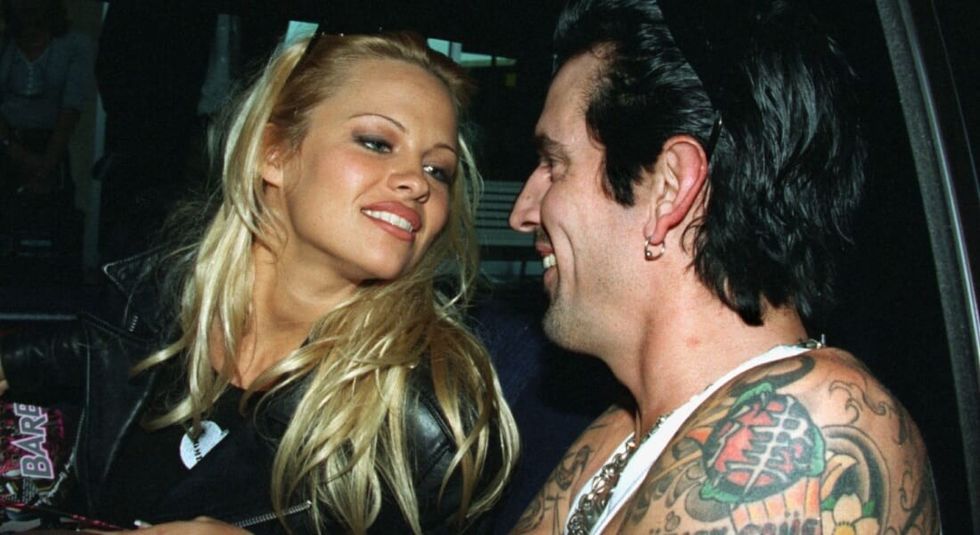 Pamela Anderson with musician Tommy Lee smiling at one another.