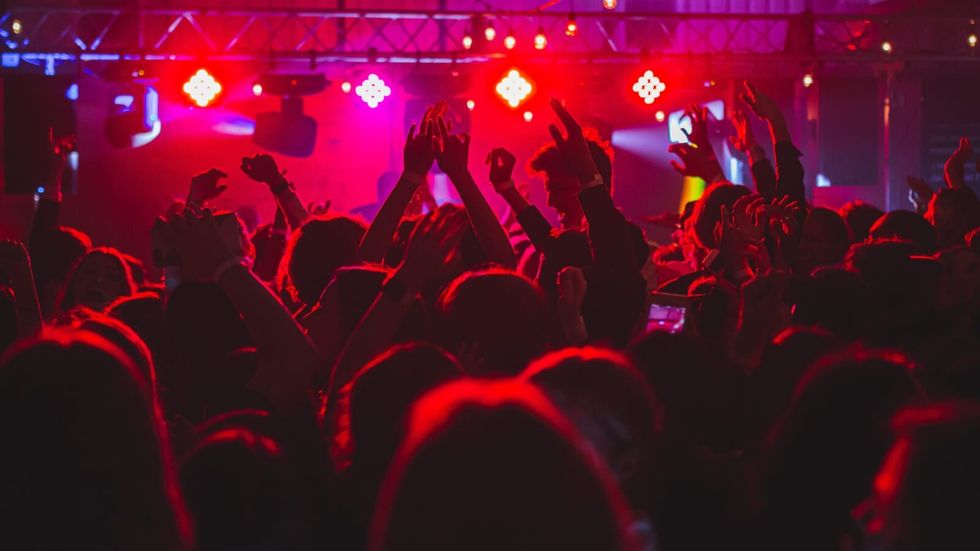 people dancing in a club, red and flashing lights