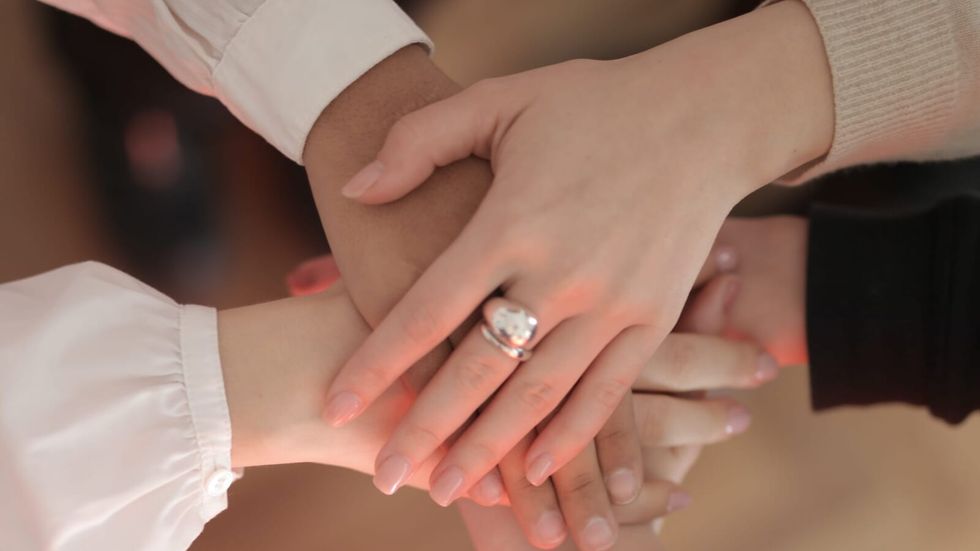 people stacking their hands on top of each other