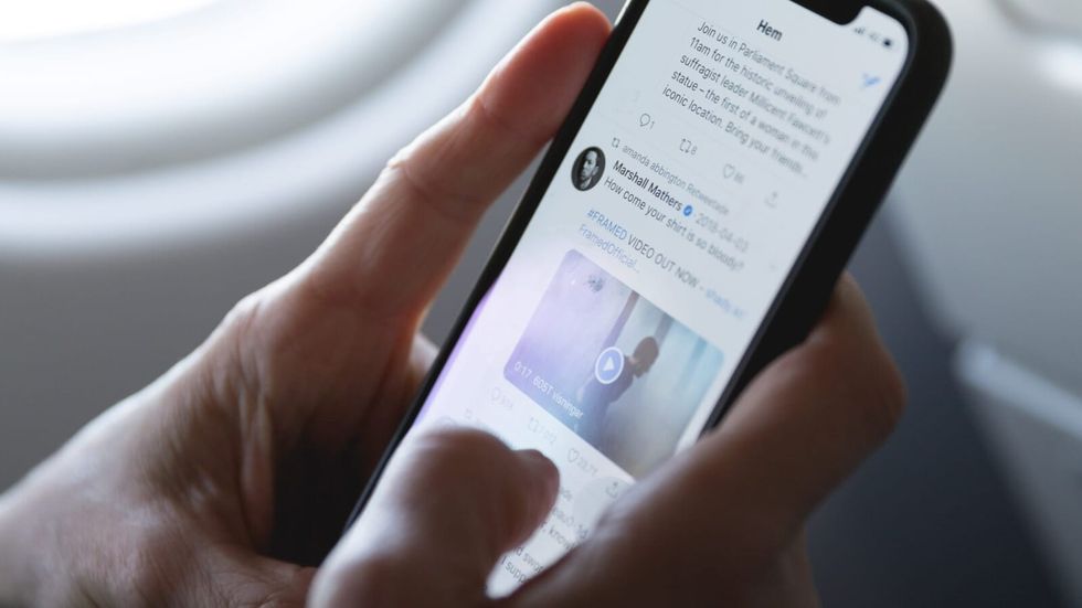 person checking twitter on their phone