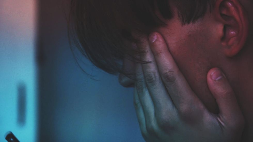 person hiding his face in his hands