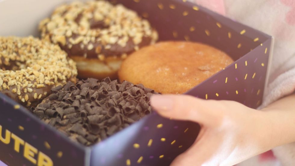 person holding a box of donuts