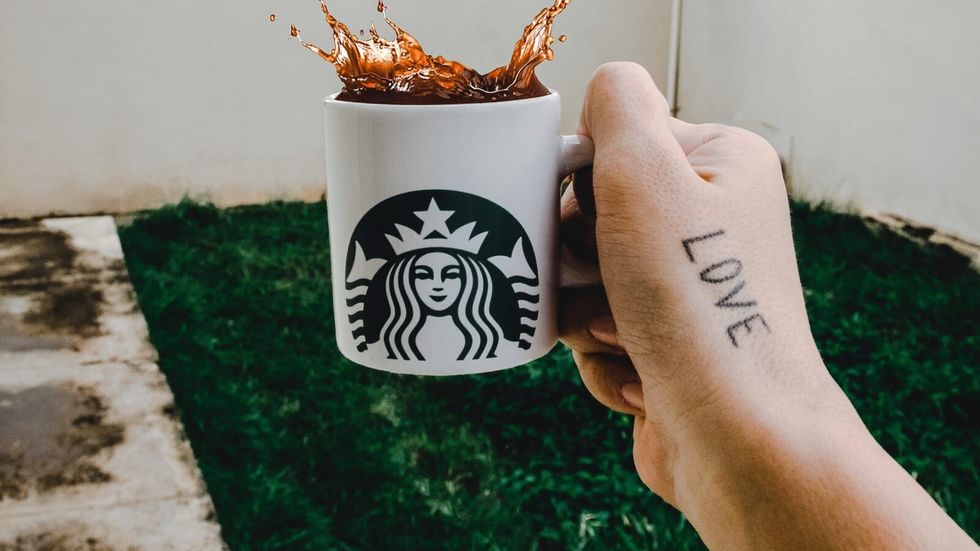 person holding a starbucks cup with coffee in it