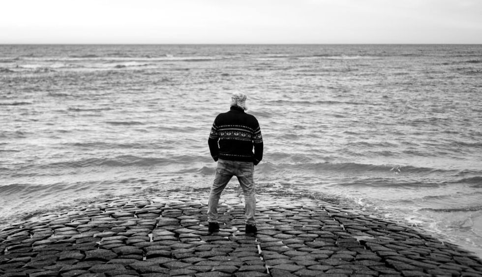 person stands by water