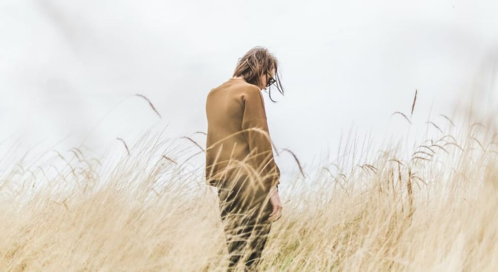 person suffers from regret standing in field